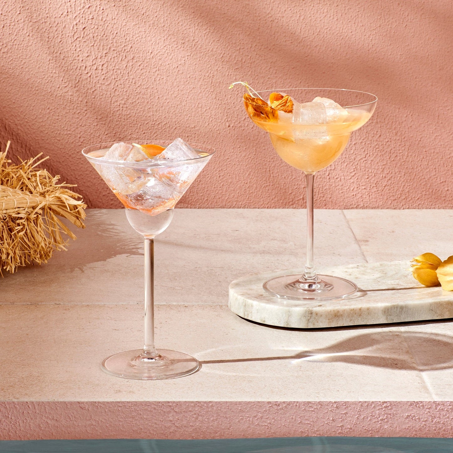 Bright and spring-forward martini cocktail against pink background.